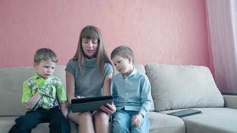 mother and two sons playing tablet