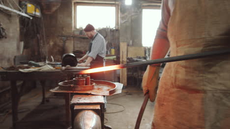 blacksmith forging wrought iron spiral in workshop