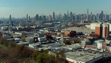 Forwards-fly-above-historic-Calvary-Cemetery-and-surrounding-town-borough.-Modern-high-rise-buildings-in-background.-New-York-City,-USA