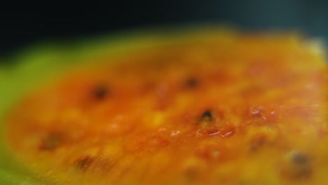 macro detailed video of a sliced sabra, orange open tropical cactus fruit with seeds, smooth pull back movement, slow motion 120fps