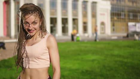 Junges-Schönes-Mädchen-Mit-Dreadlocks,-Das-In-Einem-Park-Tanzt.-Schöne-Frau-In-Jeans,-Die-An-Einem-Sonnigen-Tag-Musik-Hört-Und-Tanzt