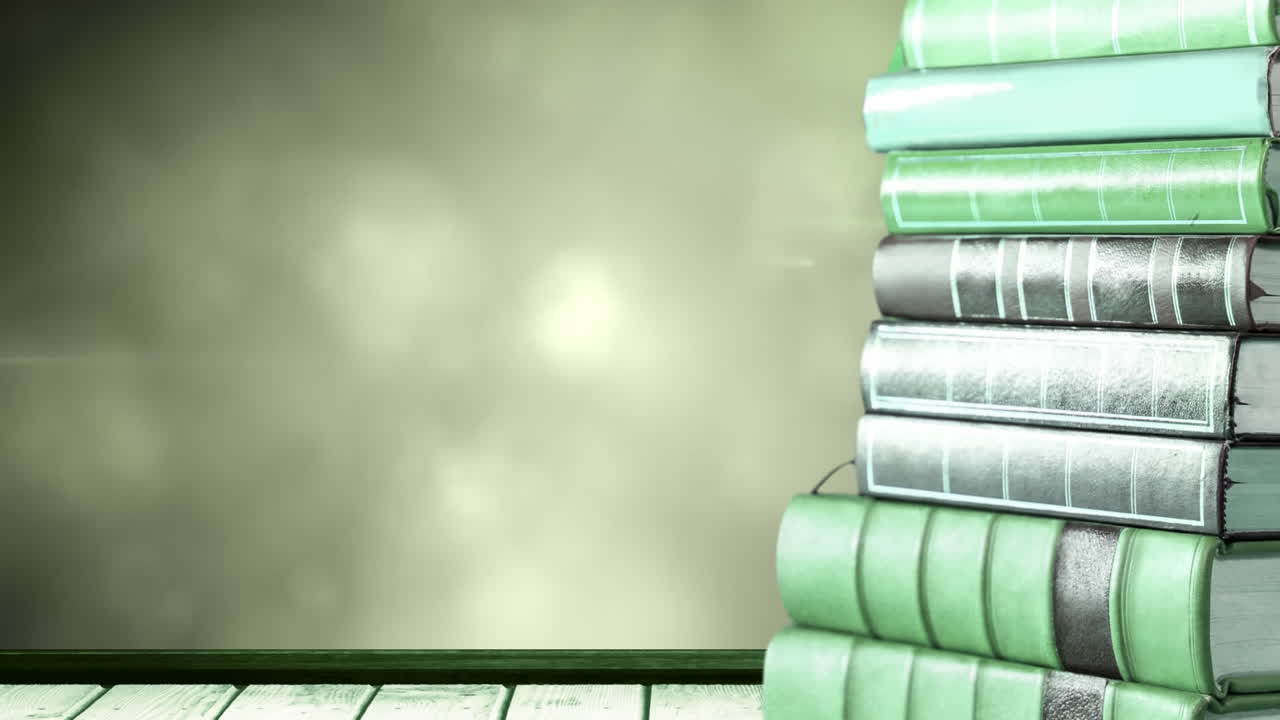 Animation of stack of books with copy space over glowing green lights