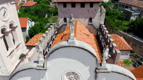 statues on top of fortified church of st. mary’s assumption in jelsa, hvar, croatia. - aerial ascend shot
