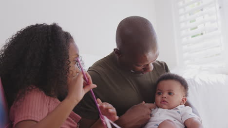 Father-And-Daughter-Dressed-As-Fairy-Sitting-In-Bedroom-Playing-With-Baby-Brother