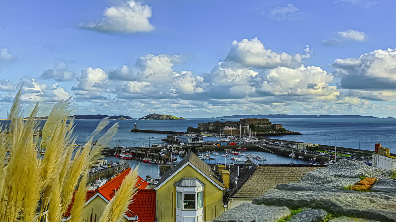 건지의 일몰 시간 동안 세인트 피터 포트 항구와 아름다운 바다 경치를 저속 촬영했습니다.