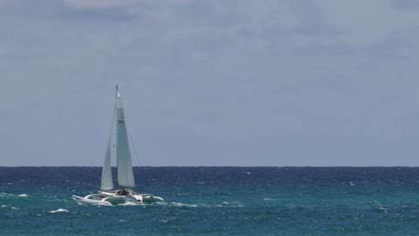 sailboat moving across the blue ocean under clear skies