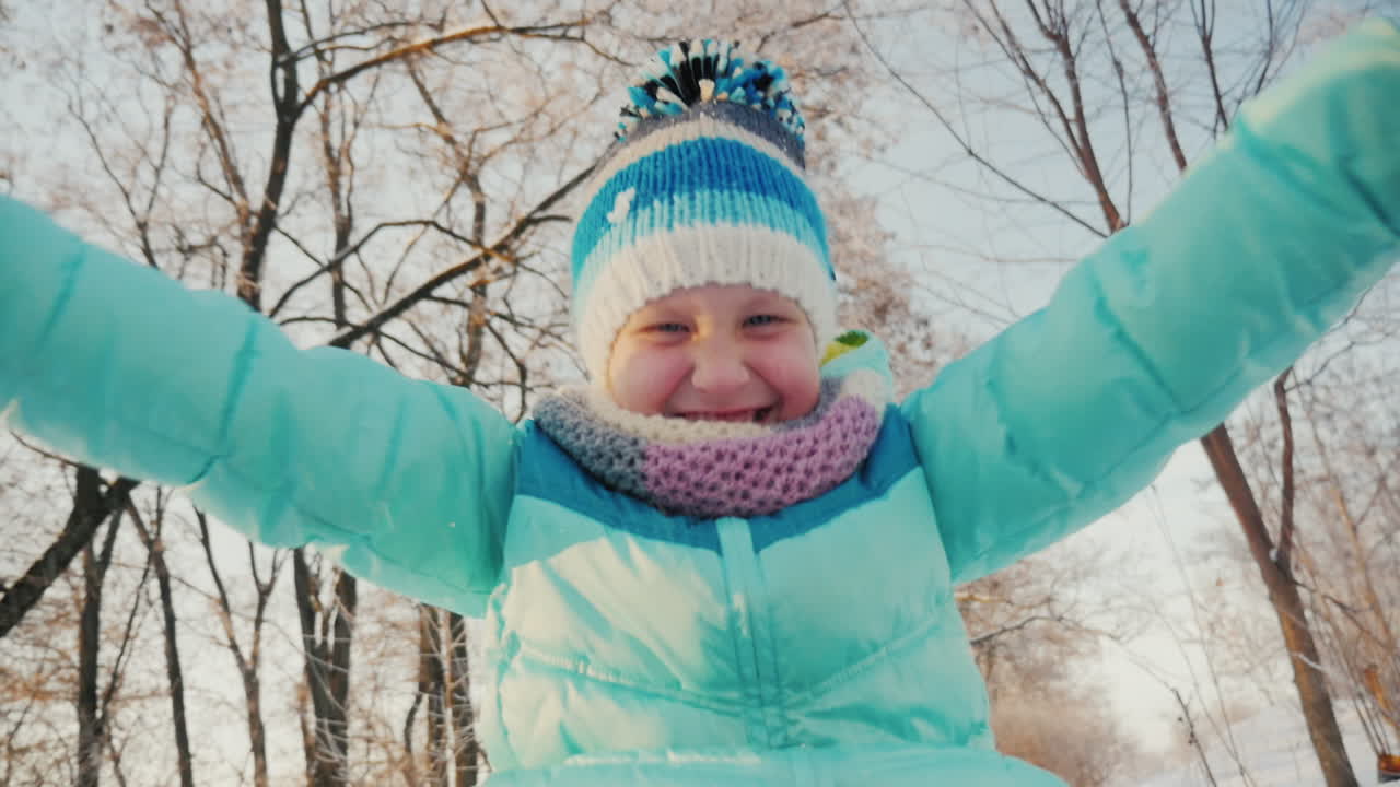 niña alegre va en un trineo aplaude sus manos es feliz invierno 2
