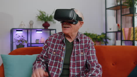 senior man using vr headset helmet app to play simulation game watching virtual reality video home