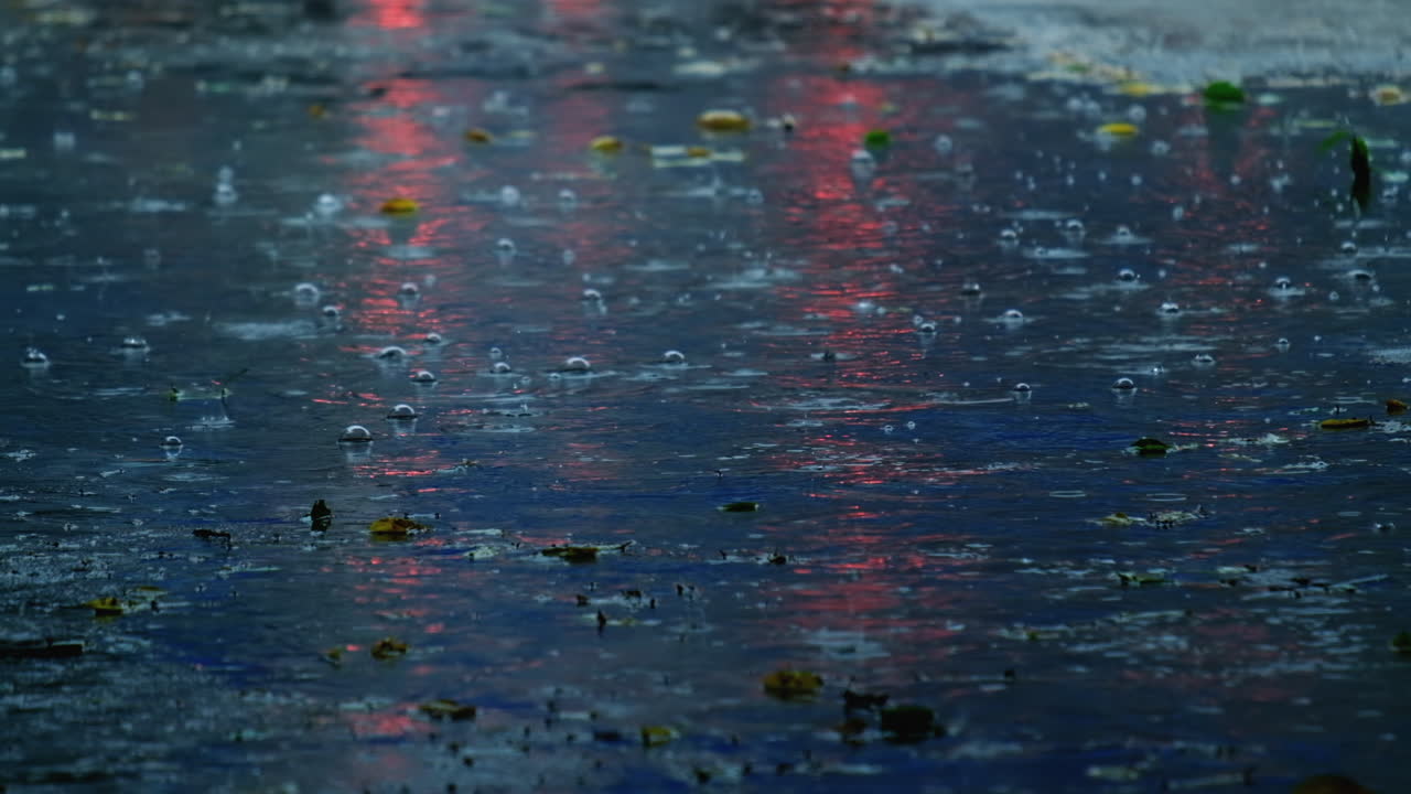 Slow motion of raindrops falling on submerged road in rainy season