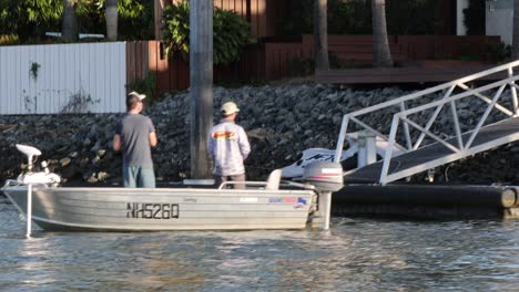 two people docking a boat at a pier