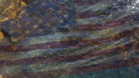 Digital-composition-of-waving-us-flag-against-sea-waves-hitting-the-rocks