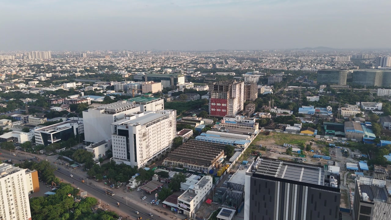 Aerial drone shot of corporate buildings with traffic below surrounded by buildings