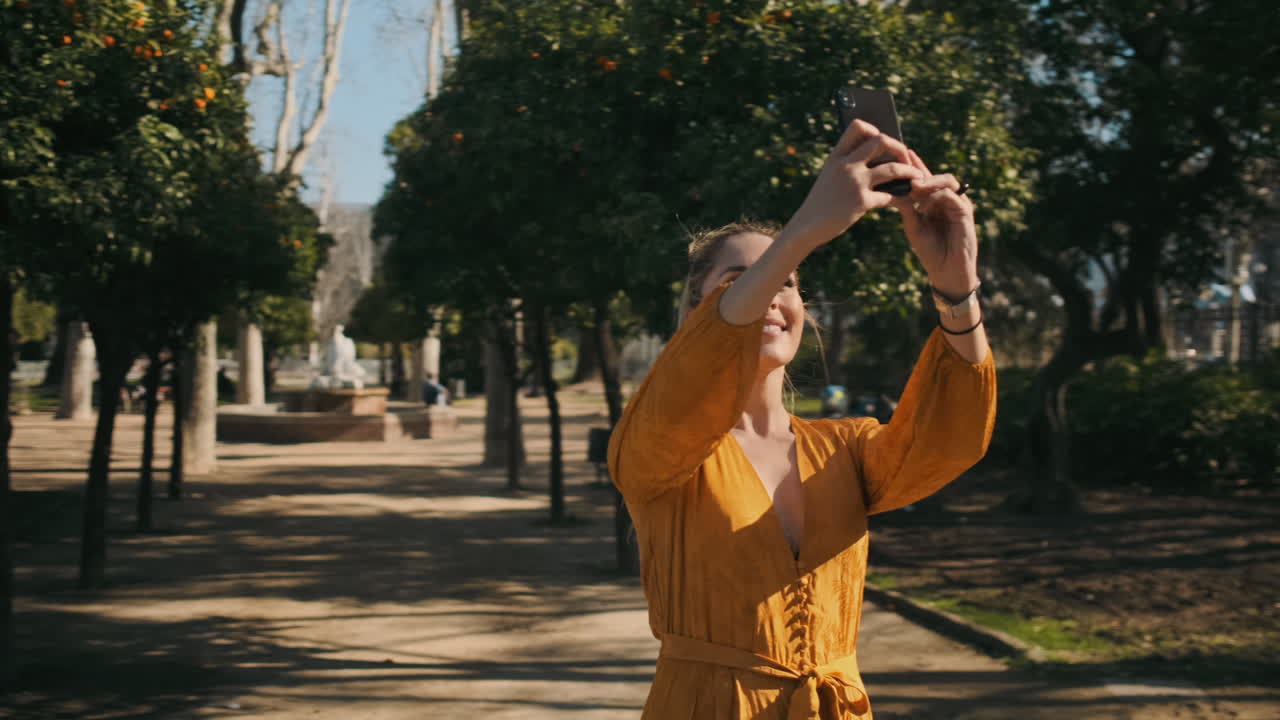 una joven elegante tomando fotos al aire libre.