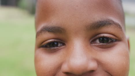 Video-portrait-close-up-of-smiling-african-american-schoolboy-in-playing-field