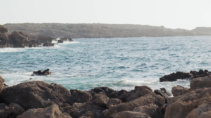 Ripresa al rallentatore di bellissime onde selvagge che si infrangono in una baia rocciosa con vista sull'oceano, Elafonissi, Creta.