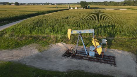 pumpjack pumping oil in countryside of michigan, aerial view