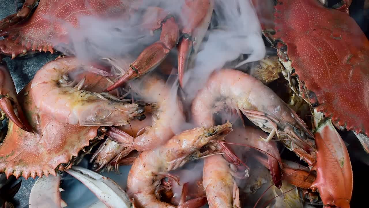 김이 모락모락 나는 뜨거운 꽃게와 큰 새우가 더미 위에 놓여 있다
