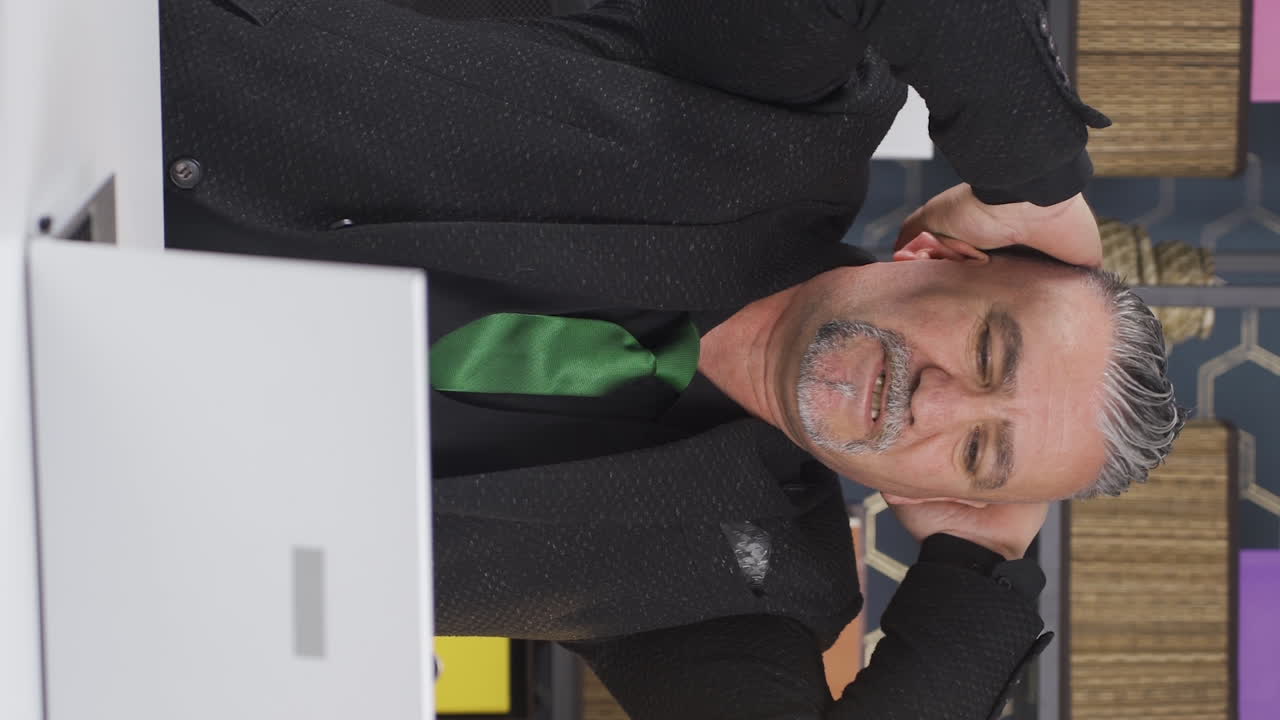 Vertical video of Businessman looking at camera tired from work.