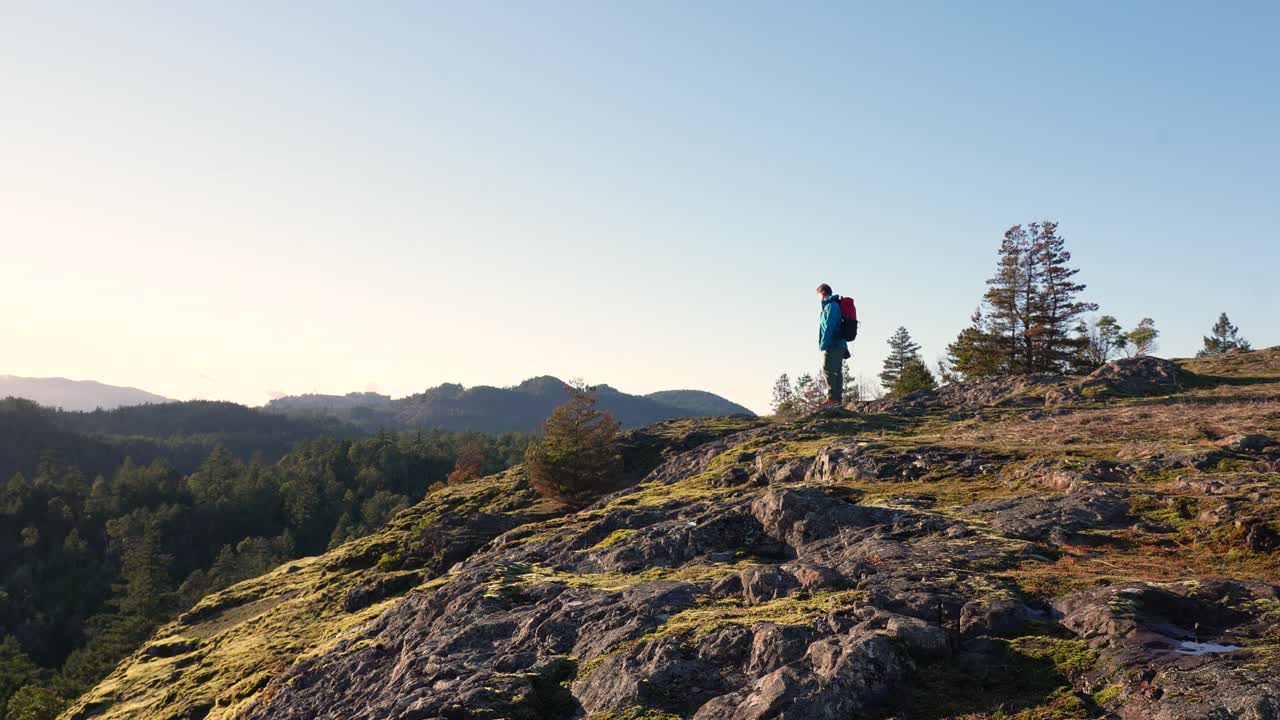 excursionista masculino en una cresta de rock bluff en la isla de vancouver, canadá, lone tree hill