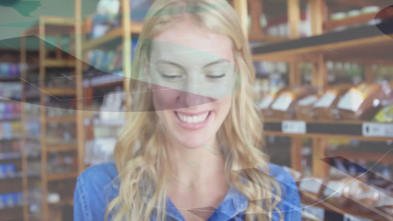 그녀의 위에 추상적인 모양의 애니메이션을 가진 상점에서 미소 짓는 여자