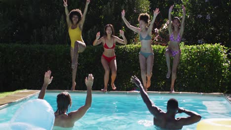 Eine-Vielfältige-Gruppe-Von-Freunden,-Die-Spaß-Daran-Haben,-In-Ein-Schwimmbad-Zu-Springen