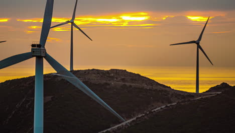 Turbina-Eólica-De-Lapso-De-Tiempo-Generando-Electricidad-Usando-Viento-Con-Cielos-Anaranjados-Y-Nubes-Moviéndose-Por-El-Cielo