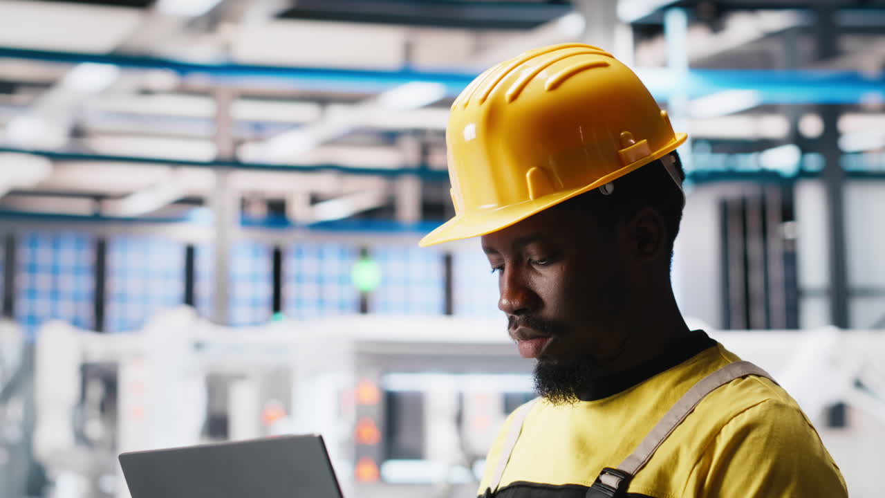 Vertical Video Photovoltaics factory technician optimizing production flow using laptop