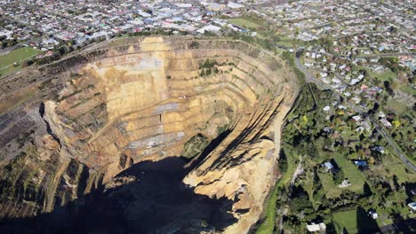 gold mining pit, aerial reveal of small town waihi, new zealand industry