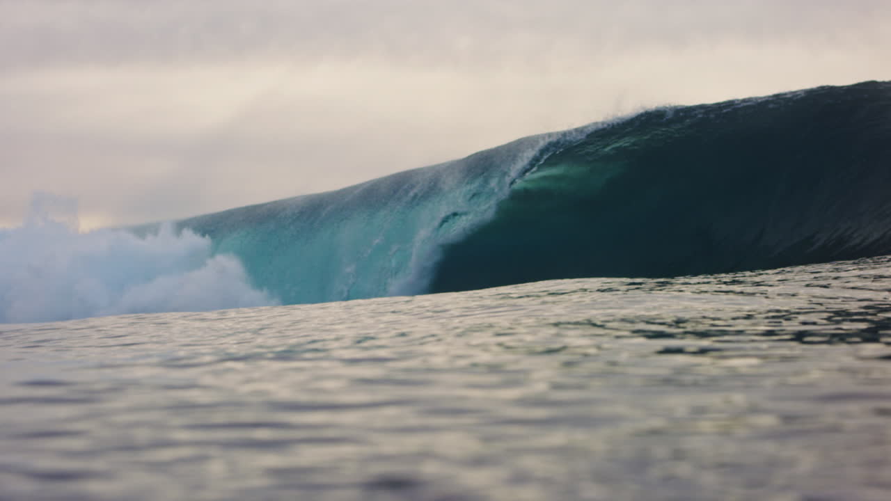 vista de ángulo bajo de las olas oceánicas que se estrellan en la superficie del agua en cámara lenta