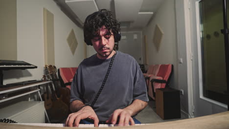 piano player musician playing piano alone in his home studio while recording