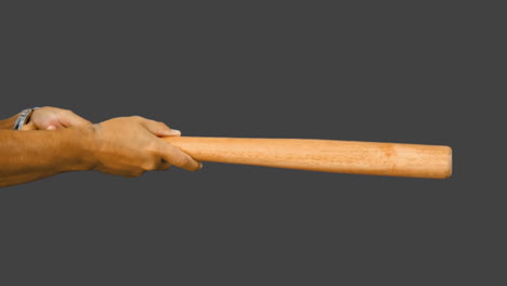 hombre golpeando el béisbol con un bate de madera y manteniéndolo