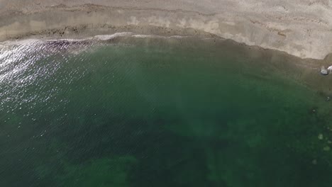 Aerial-View-Tilting-Up-Over-Water-Revealing-a-Beach-at-Moresby-Island,-Columbia,-Canada