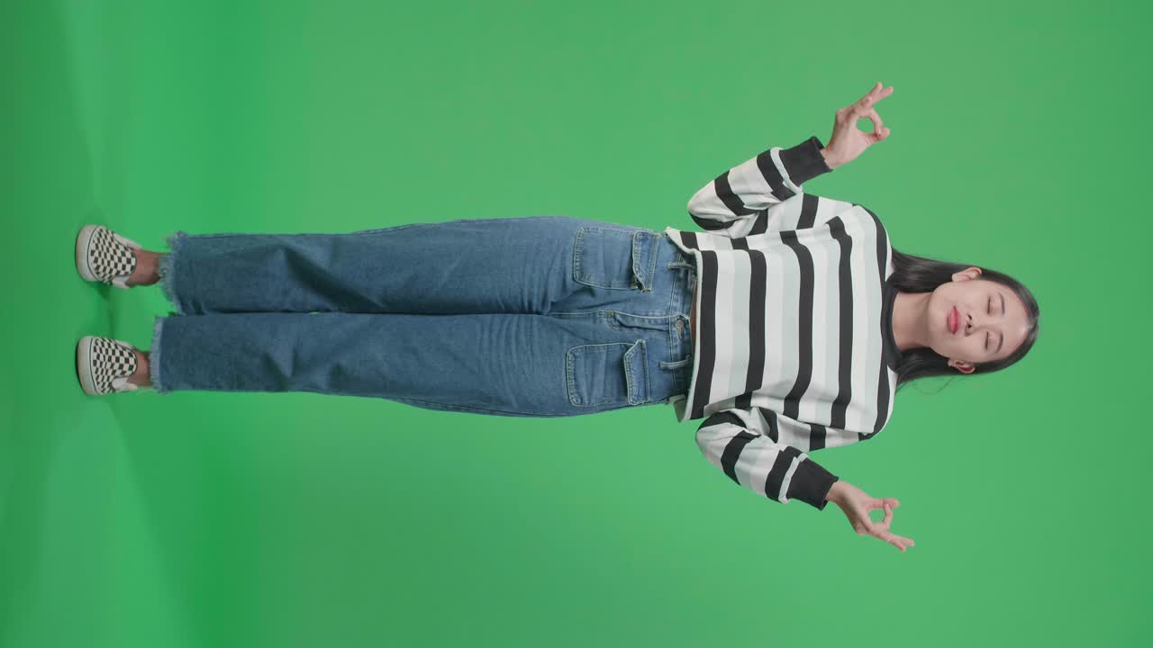 Woman meditating in front of green screen