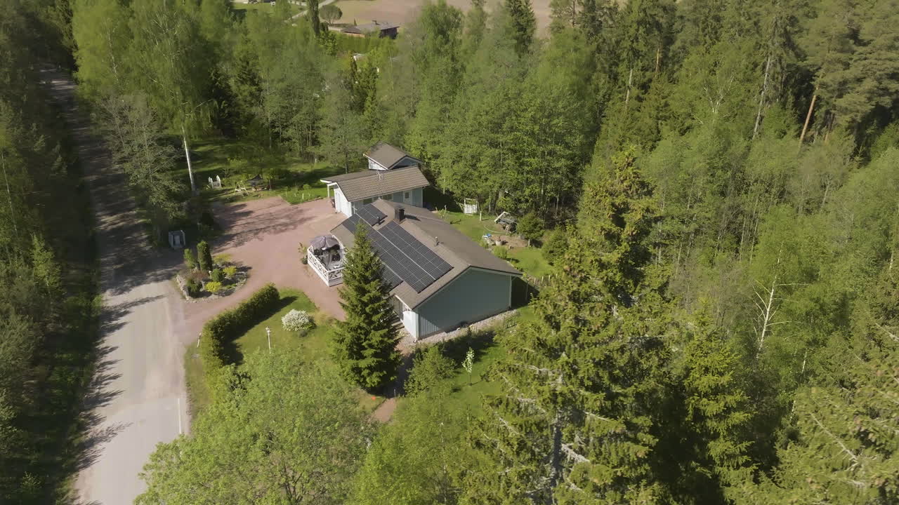 Luftfoto af et solcelledrevet hus, der kredser midt i solrigt forårsgrønt.