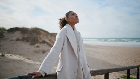 Stylish-black-hair-girl-taking-break-relaxing-at-ocean-shore.-Calm-woman-dream