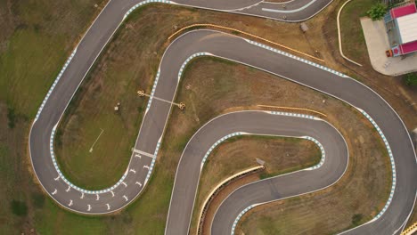 rising top down drone shot of a go kart race track completely empty