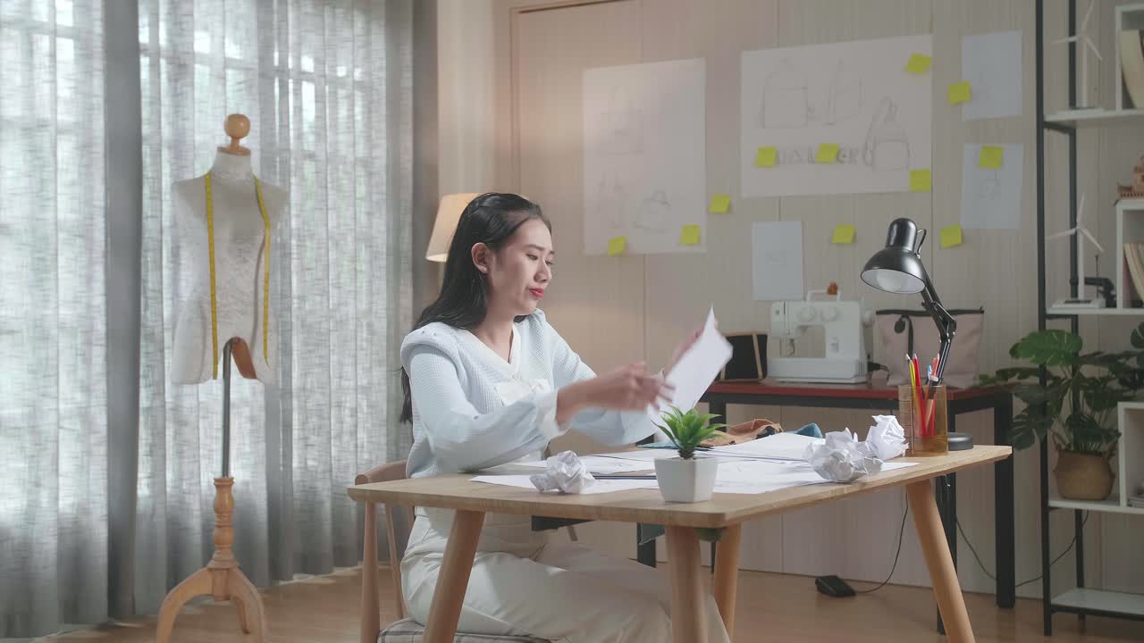 아시아 여성 디자이너는 레이아웃을 그리는 데 실패하고 그것을 버리고 화가 나 있습니다.