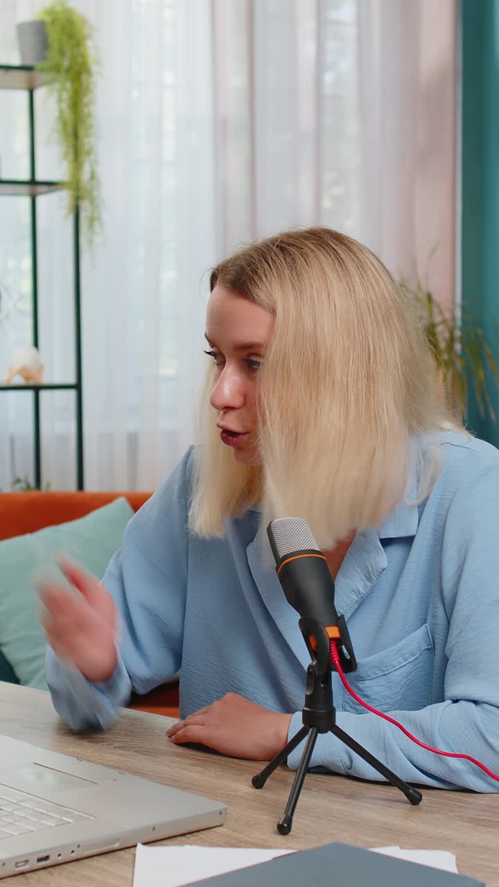 blogger mujer feliz grabando podcast en la mesa dando taller webinar hablando en el micrófono portátil