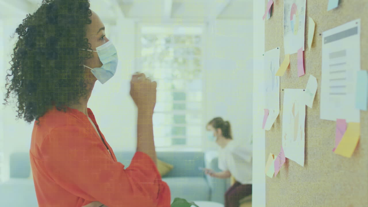 Animation of data processing over businesswomen wearing face masks