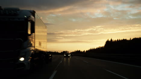 Driving-on-highway-in-Germany-at-sunrise-in-traffic