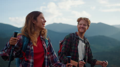 laughing couple trekking mountains. close up two tourists smile together outside
