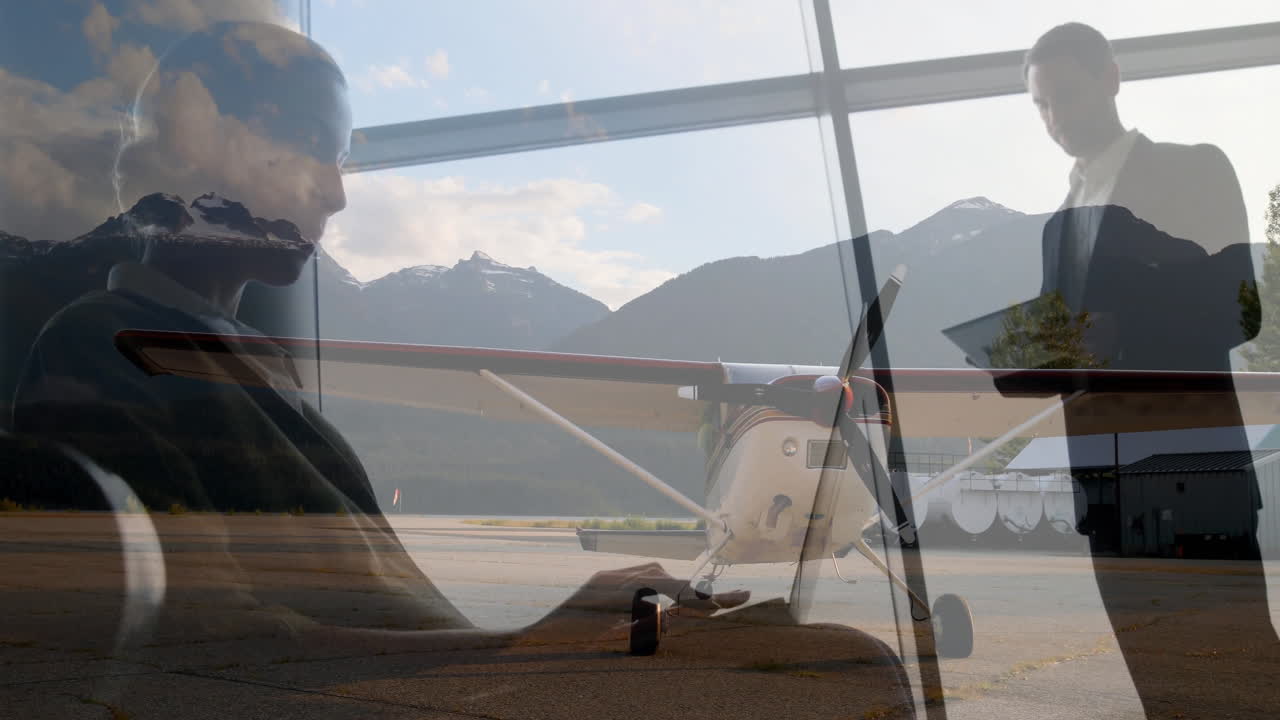 On runway, business professionals using digital devices beside small airplane