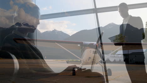 on runway, business professionals using digital devices beside small airplane