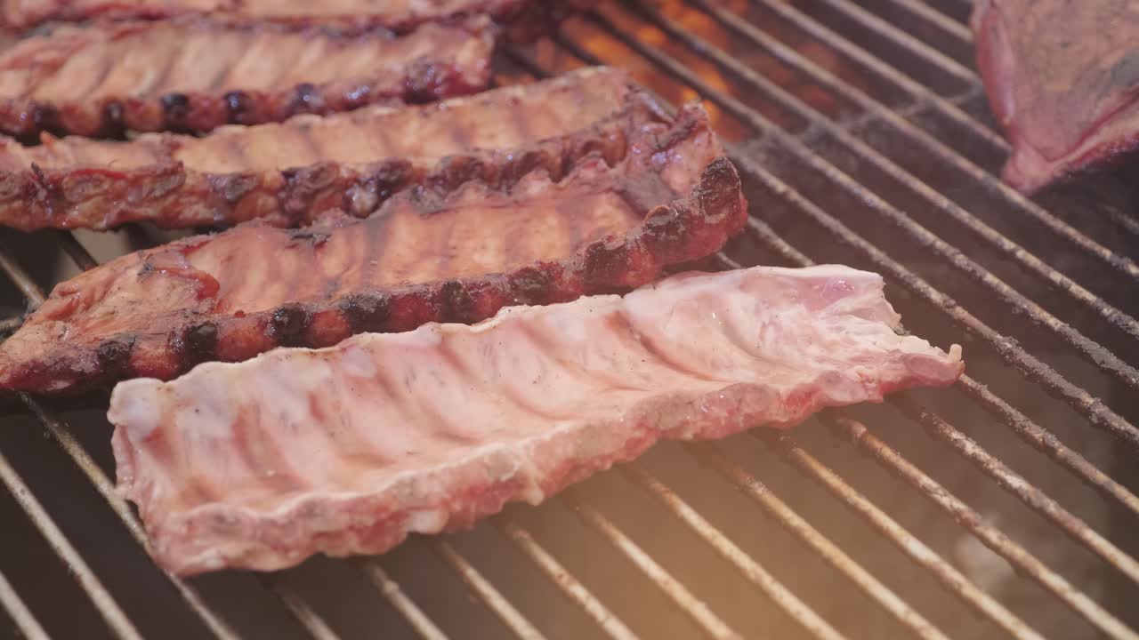 요리사는 손으로 그릴 고기를 바로잡습니다.