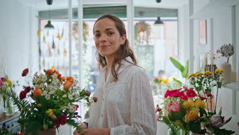 closeup happy flower retailer look camera in plant shop workplace. work concept.