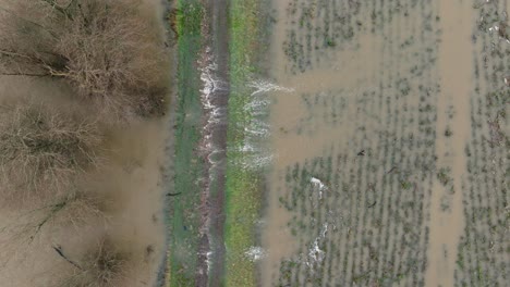 Vista-Aérea-Media-De-Las-Aguas-De-La-Inundación-Que-Invadieron-Un-Impuesto-E-Inundaron-Un-Campo-Agrícola-A-Lo-Largo-Del-Río-Waal-Cerca-De-La-Ciudad-De-Gorinchem-Después-De-Que-Las-Fuertes-Lluvias-Azotaran-El-Norte-De-Europa.