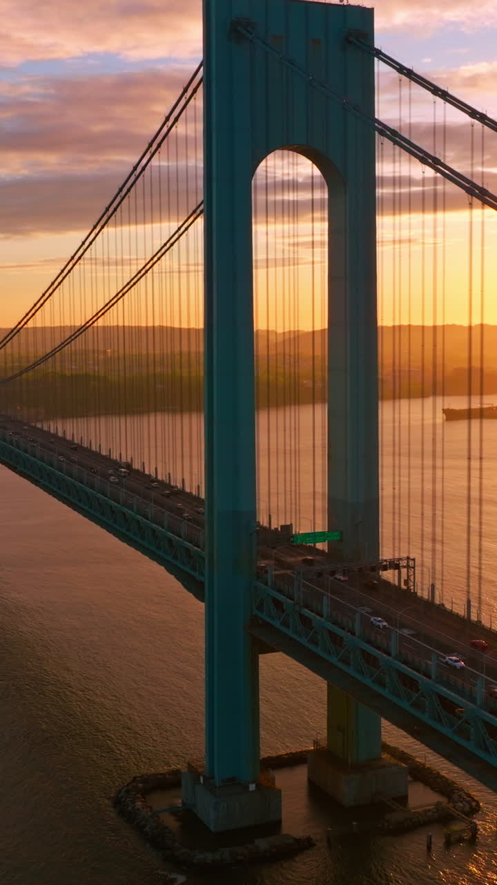 Splendid view of Whitestone bridge over the East River. Fantastic sight of the bridge at the backdrop of setting sun and pink clouds. Vertical video