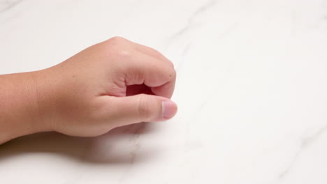 close-up of hand knuckle knocking on a surface of a wall