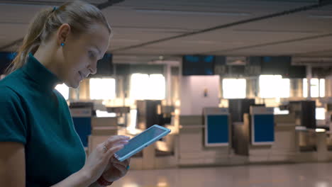 Frau-Mit-Tablet-Am-Check-in-Schalter-Am-Flughafen