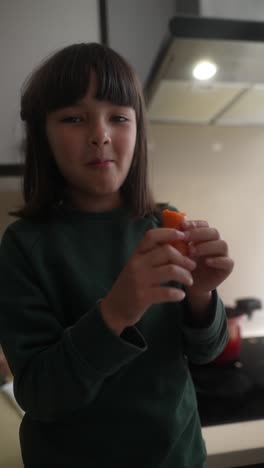 girl eating a carrot in the kitchen